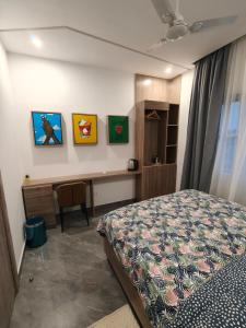 a bedroom with a bed and a desk with paintings on the wall at La Villa K - 1 Studio in Lomé