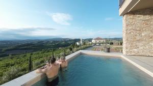 a group of three people sitting in a swimming pool at Villa EVA Resort & Boutique in Dobrovo