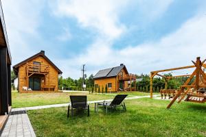 a log cabin with chairs and a playground at OlszeVita in Szteklin