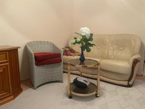 a living room with a couch and a table with a vase of flowers at Ferienwohnung Weinstrasse in Rostock