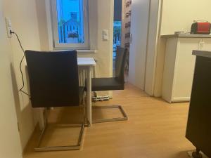 a table and chairs in a room with a window at Ferienwohnung Weinstrasse in Rostock