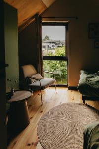 ein Zimmer mit einem Stuhl, einem Tisch und einem Fenster in der Unterkunft Otuli in Ćmińsk