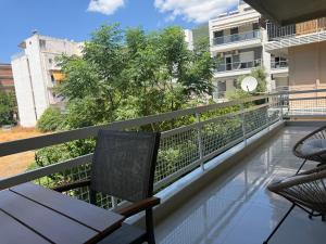 a balcony with a bench and chairs on a building at Loutraki Sea Breeze Sunset Apt in Loutraki