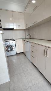 a kitchen with white cabinets and a washing machine at Olesya Guesthouse in Mtsvane Konts'khi +57 photos