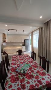 a dining room with a table with a red floral table cloth at Olesya Guesthouse in Mtsvane Konts'khi