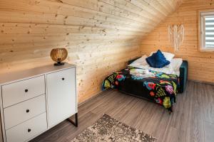 a bedroom with a bed in a wooden wall at OlszeVita in Szteklin +18 photos