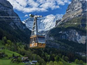 a cable car flying over a mountain at Eiger View in Grindelwald
