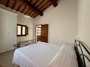 a bedroom with a white bed in a room at Casa L Oleandro in Torrenieri