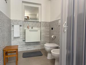 a bathroom with a toilet and a sink and a mirror at Casa L Oleandro in Torrenieri