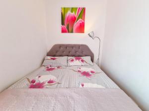 a bedroom with a bed with pink flowers on it at Tawerna Michałowscy in Mielno +41 photos