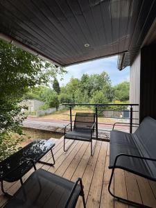 a porch with chairs and a bench on a deck at Charmante maison indépendante avec jardin, 45 m2, clim, parking in Mondeville