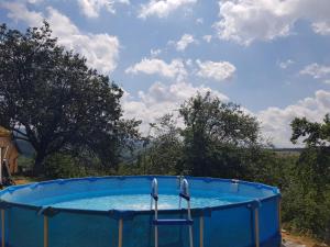 a large blue pool with two chairs in it at Meziad-Panorama in Meziad