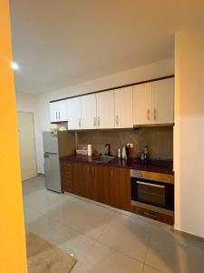 a kitchen with wooden cabinets and a refrigerator at Florida apartments in Golem