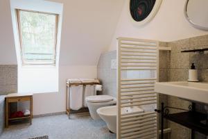 a bathroom with a toilet and a sink and a window at Weingut Bleyweis in Kitzeck im Sausal +27 photos