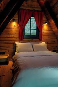 a bedroom with a large bed with a window at Ötüken Dağ Evleri in Akcaabat