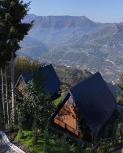 a house on a hill with mountains in the background at Ötüken Dağ Evleri in Akcaabat +7 photos