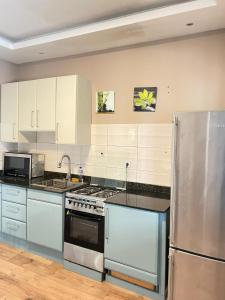 a kitchen with a stove and a refrigerator at Appartement Güstrow "free energy from solar Panels" in Lomé