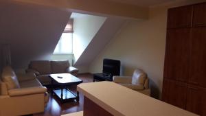 a living room with couches and a tv in a room at Apartamenty Sokółka in Sokółka