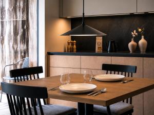 a wooden table with plates and wine glasses on it at AMIL chalets dolomites - Guests aged 14 and over in Arnbach +12 photos