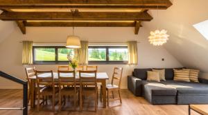 a dining room with a table and a couch at Apartmán pod Pustým vrchem in Říčky