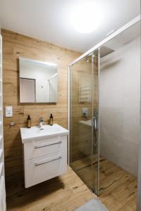 a bathroom with a white sink and a shower at Apartmán na Pasekách in Bystrzyca +27 photos