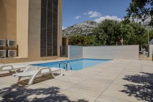 a swimming pool with two lounge chairs and a mountain at Villa francesca in Starigrad