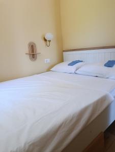 a large white bed with two blue towels on it at Pergola Garden in Nikšić