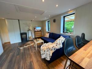 a living room with a blue couch and a table at Mysigt stuga med bastu in Edsvalla