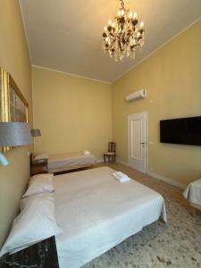 a bedroom with a large bed and a chandelier at Palazzo TEDESCHI in Borgonovo Val Tidone