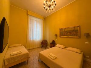 a hotel room with two beds and a chandelier at Palazzo TEDESCHI in Borgonovo Val Tidone