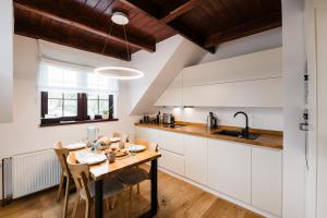 a kitchen with white cabinets and a wooden table at Apartmán na Pasekách in Bystrzyca