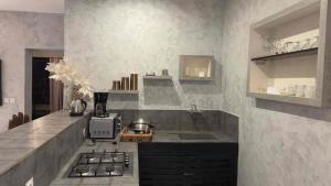 a kitchen with a sink and a stove in it at Prestige Majorelle Résidence Prestige Majorelle in Ngaparou