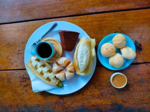 a plate of food with a cup of coffee and biscuits at Hostel e Pousada Blue Lagoon in Abraão