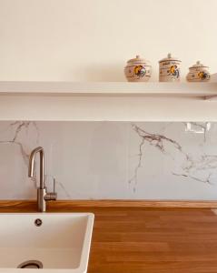 a kitchen with a sink and a shelf on the wall at Apuliantales Cottage Bari in Carbonara di Bari +34 photos