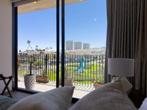 a bedroom with a large window with a view of a playground at Loft en Zibata con Vista Alberca y Gym in La Cañada