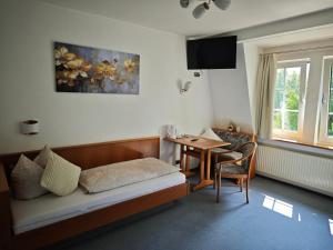 a hotel room with a bed and a table at Pension Villa Sarah in Bad Dürrheim
