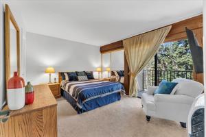 a bedroom with a bed and a chair and a window at Chez Vaupen in Alpine Meadows