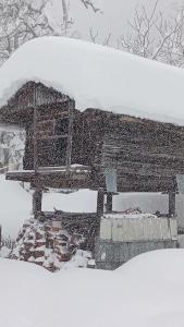 a snow covered roof of a house with a window at wila ZUNDAGA ზუნდაგა 1800 in Zundaga