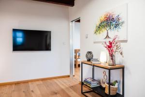 a living room with a tv and a table with flowers at Apartmán na Pasekách in Bystrzyca