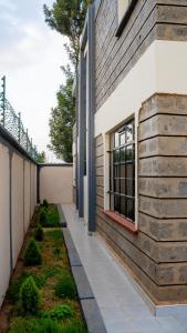 a walkway next to a building with a window at Godly Homes 5km frm Weiteithie! 4BR mdrn home in Ruiru