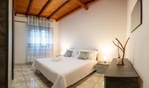 a bedroom with a white bed and a window at Amò Casa in Fiumefreddo di Sicilia