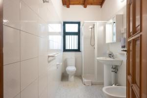a white bathroom with a toilet and a sink at Amò Casa in Fiumefreddo di Sicilia