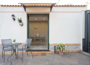 a patio with chairs and a table in front of a building at Amò Casa in Fiumefreddo di Sicilia