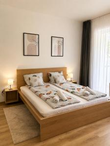 a bedroom with a large bed with two lamps on it at Barcs Thermal Apartments in Barcs