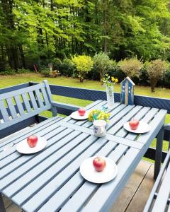a blue picnic table with plates of fruit on it at Modry Domek Szczyrk domek na wyłączność z kominkiem in Szczyrk