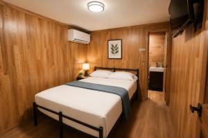 a bedroom with a large bed in a room with wooden walls at The Mint Motel in Arlington