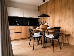 a kitchen with a wooden table and chairs at AMIL chalets dolomites - Guests aged 14 and over in Arnbach