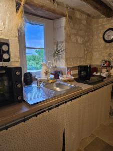 a kitchen counter with a sink and a window at L'Authentique in Mouzay +8 photos