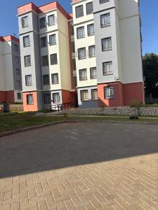 a large white building with red and white at Prestige apartments Machakos in Machakos