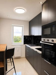 a kitchen with black cabinets and a table and a window at Apartamentul Castanilor in Ploieşti